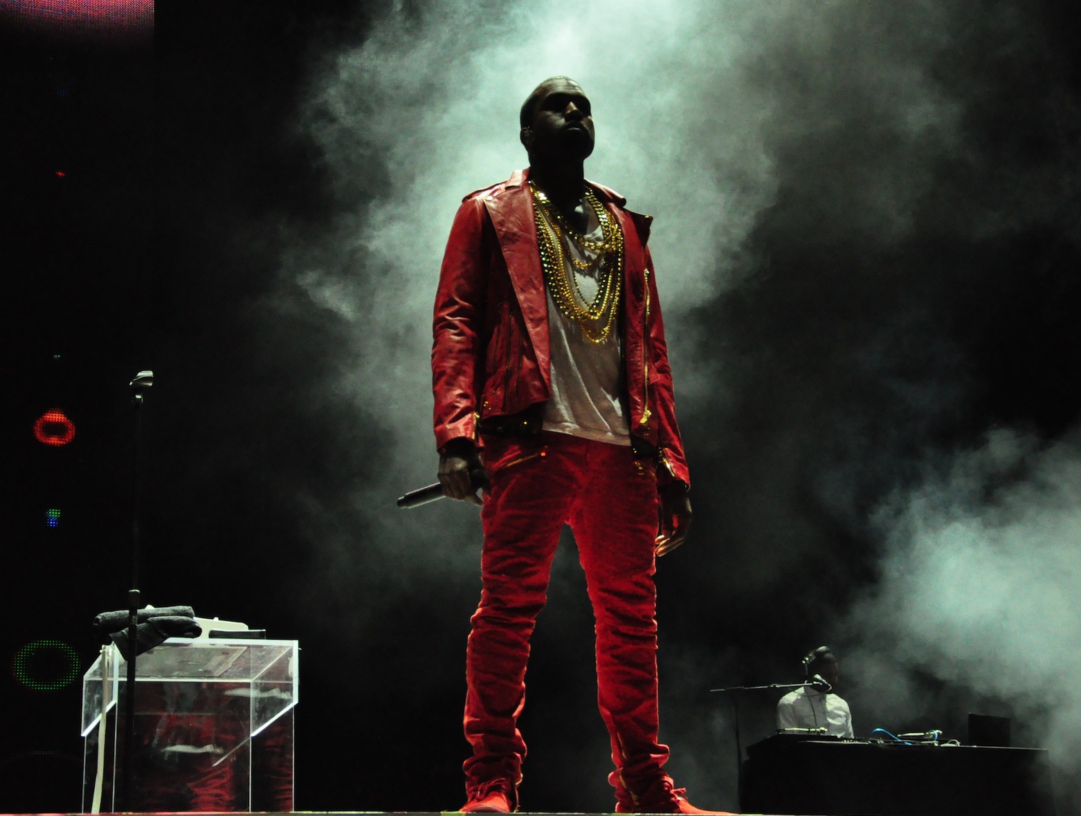 Kanye in a red suit singing on stage
